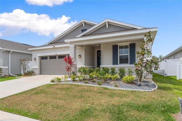 6003 Nightjar Ct, Okahumpka, FL 34762 - craftsman-style home with fence, stone siding, driveway, a front lawn, and a garage