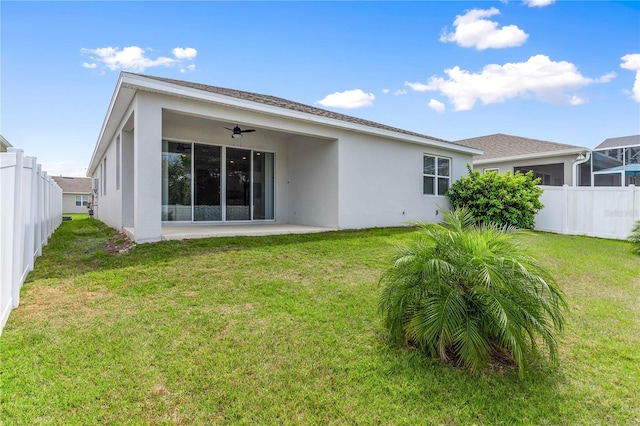 6003 Nightjar Ct, Okahumpka, FL 34762 - back of property with a fenced backyard, a ceiling fan, stucco siding, and a lawn