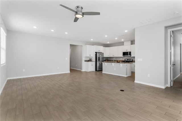 6003 Nightjar Ct, Okahumpka, FL 34762 - unfurnished living room with baseboards, light wood-style flooring, ceiling fan, and recessed lighting