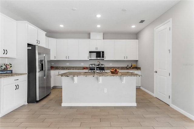 6003 Nightjar Ct, Okahumpka, FL 34762 - kitchen featuring a kitchen breakfast bar, stainless steel appliances, light stone counters, and visible vents