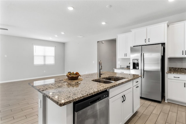 6003 Nightjar Ct, Okahumpka, FL 34762 - kitchen with a sink, light stone countertops, appliances with stainless steel finishes, wood finish floors, and a kitchen island with sink