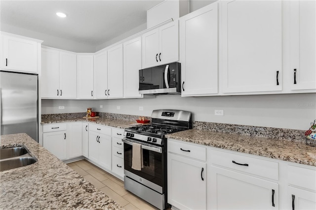 6003 Nightjar Ct, Okahumpka, FL 34762 - kitchen with light stone counters, white cabinetry, appliances with stainless steel finishes, wood tiled floor, and recessed lighting