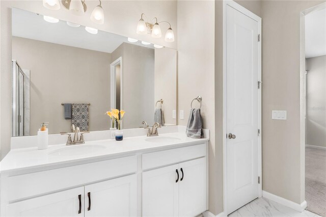 6003 Nightjar Ct, Okahumpka, FL 34762 - bathroom featuring marble finish floor, double vanity, baseboards, and a sink