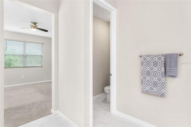 6003 Nightjar Ct, Okahumpka, FL 34762 - bathroom featuring marble finish floor, toilet, baseboards, and ceiling fan