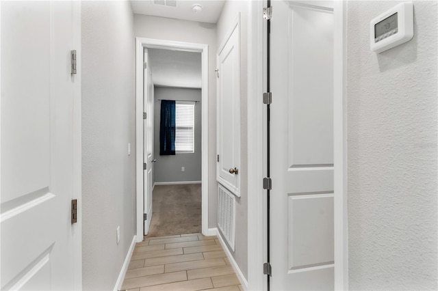 6003 Nightjar Ct, Okahumpka, FL 34762 - hallway with baseboards, a textured wall, visible vents, and wood finish floors
