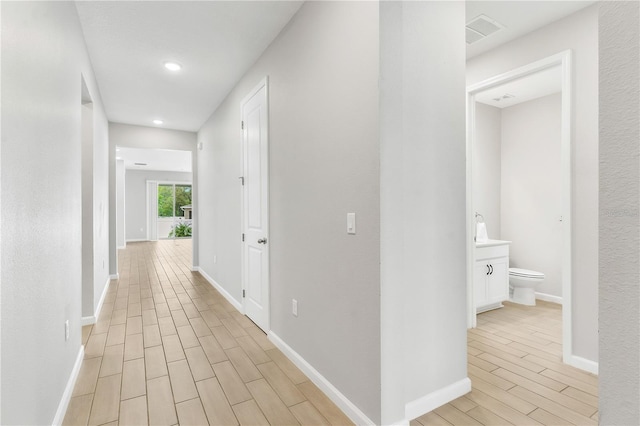6003 Nightjar Ct, Okahumpka, FL 34762 - hallway featuring wood finish floors, baseboards, and visible vents