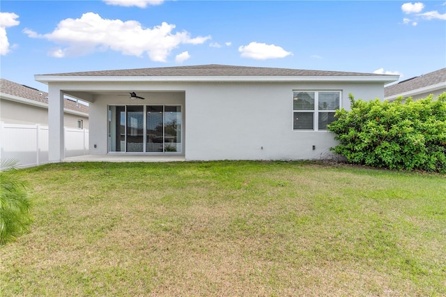 6003 Nightjar Ct, Okahumpka, FL 34762 - rear view of property with fence, stucco siding, a yard, and ceiling fan