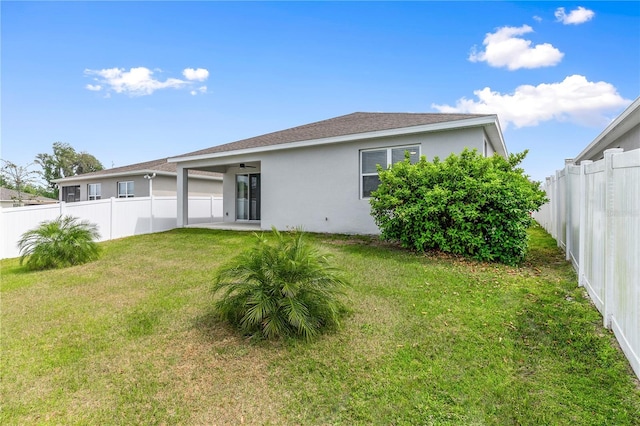 6003 Nightjar Ct, Okahumpka, FL 34762 - rear view of property featuring a lawn, a ceiling fan, a fenced backyard, and stucco siding