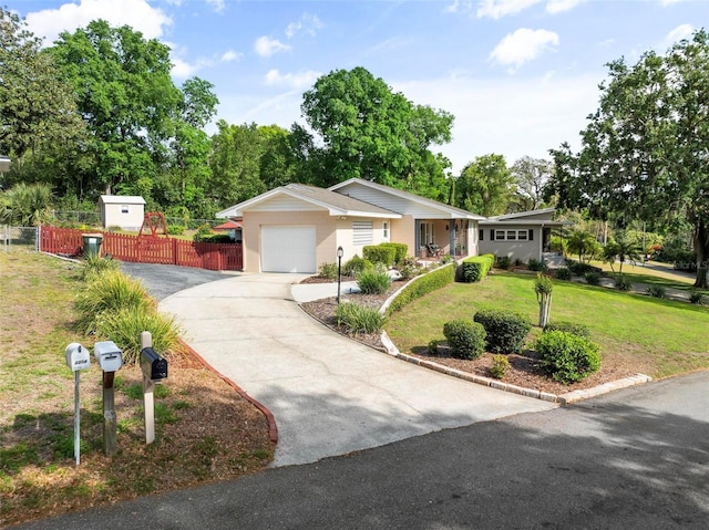 ranch-style home featuring a front yard, concrete driveway, a garage, and fence