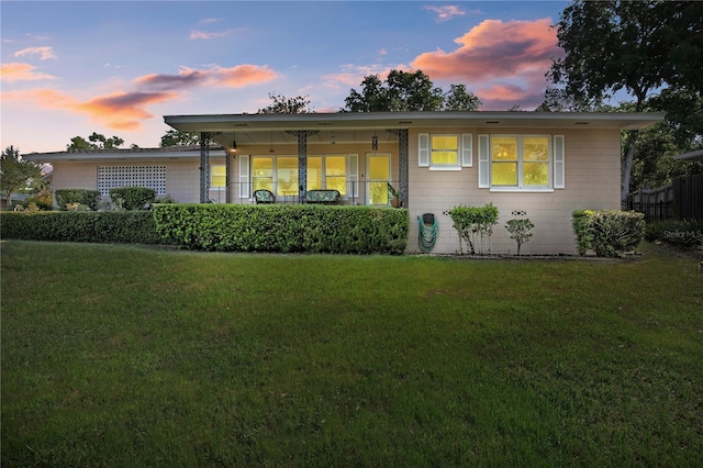 ranch-style home with fence and a yard