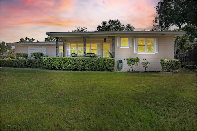 ranch-style house with fence and a yard