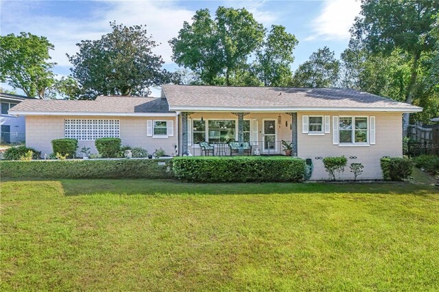 ranch-style house with a front lawn, a porch, and brick siding