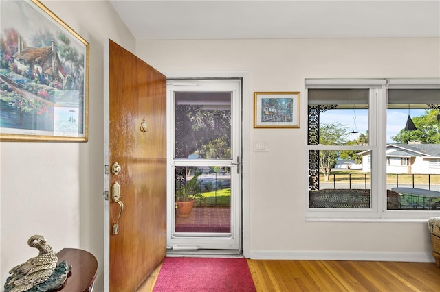 doorway to outside with baseboards and wood finished floors