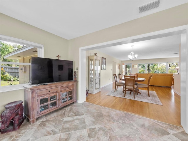 dining room featuring baseboards, visible vents, a notable chandelier, and plenty of natural light