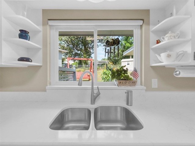 room details featuring light countertops, a sink, and open shelves