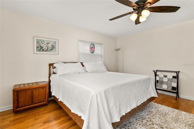 bedroom with a ceiling fan, baseboards, and light wood-style floors