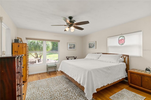 bedroom featuring baseboards, light wood-type flooring, and ceiling fan