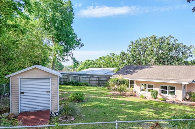 view of yard featuring an outbuilding, fence, and a storage shed