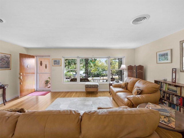 living area featuring baseboards, visible vents, and light wood-style flooring