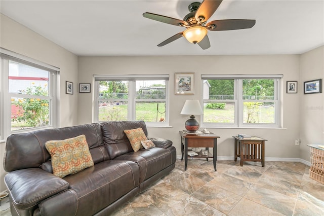 living area featuring baseboards and ceiling fan