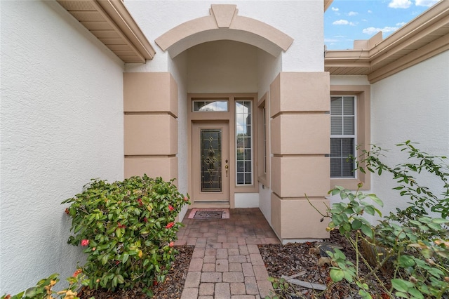 entrance to property featuring stucco siding