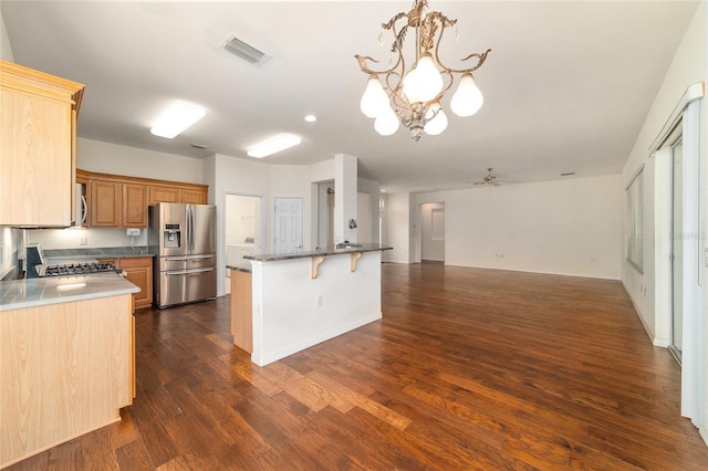 kitchen with open floor plan, stainless steel appliances, a breakfast bar, dark wood finished floors, and visible vents