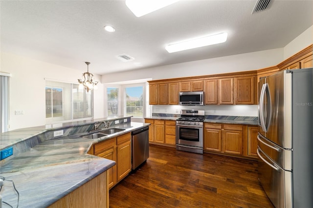 kitchen with dark wood-style flooring, visible vents, brown cabinets, stainless steel appliances, and a sink