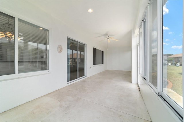 unfurnished sunroom featuring a ceiling fan