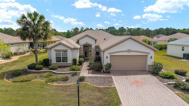 view of front of house with central air condition unit, decorative driveway, an attached garage, a front lawn, and stucco siding