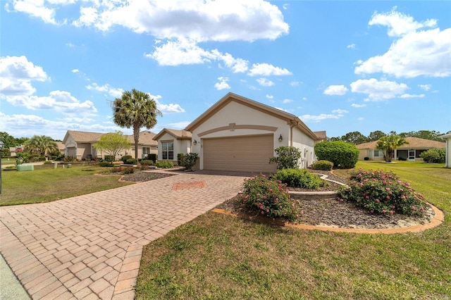 ranch-style home with stucco siding, an attached garage, a front lawn, and decorative driveway