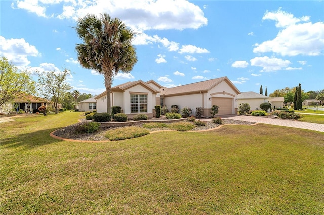 single story home featuring driveway, an attached garage, a front lawn, and stucco siding