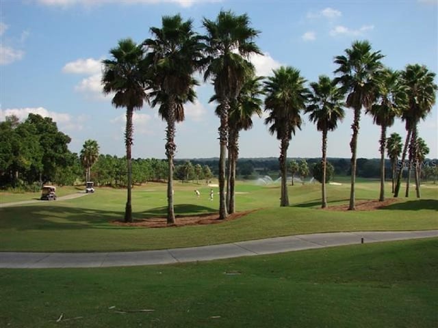 view of community with a lawn and view of golf course