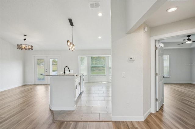 2575 SE 75th Blvd, Bushnell, FL 33513 - kitchen with visible vents, a healthy amount of sunlight, light wood-type flooring, and light stone counters