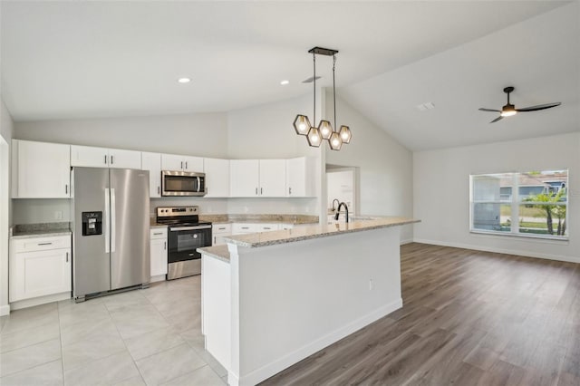 2575 SE 75th Blvd, Bushnell, FL 33513 - kitchen with white cabinets, baseboards, stainless steel appliances, decorative light fixtures, and light stone counters