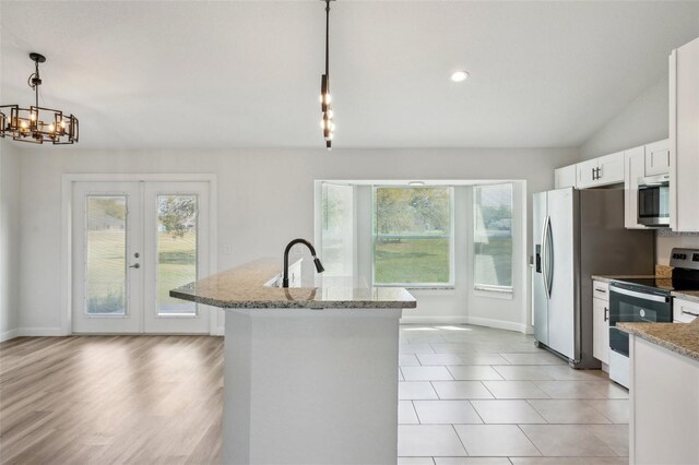 2575 SE 75th Blvd, Bushnell, FL 33513 - kitchen with white cabinetry, vaulted ceiling, hanging light fixtures, light stone countertops, and appliances with stainless steel finishes