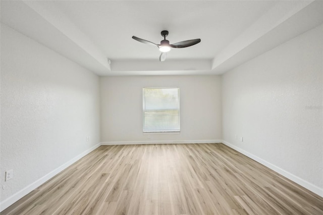 2575 SE 75th Blvd, Bushnell, FL 33513 - spare room featuring a tray ceiling, baseboards, light wood finished floors, and ceiling fan