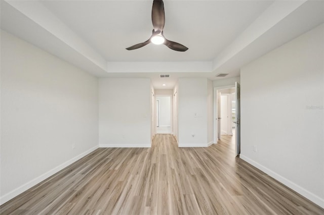 2575 SE 75th Blvd, Bushnell, FL 33513 - unfurnished room featuring visible vents, light wood finished floors, baseboards, ceiling fan, and a tray ceiling