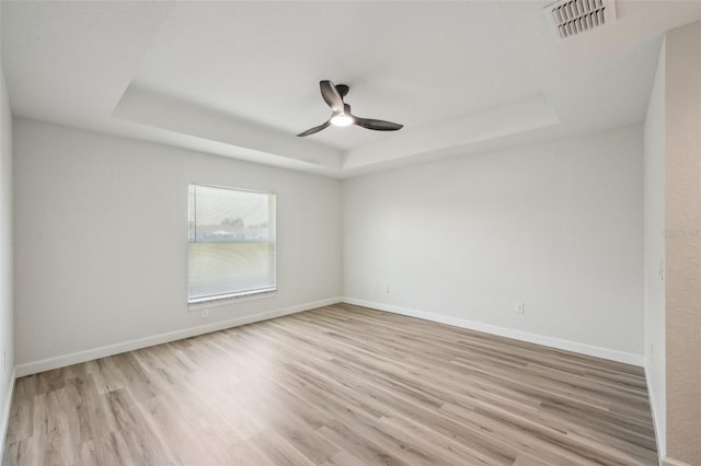 2575 SE 75th Blvd, Bushnell, FL 33513 - spare room featuring baseboards, visible vents, wood finished floors, and a raised ceiling
