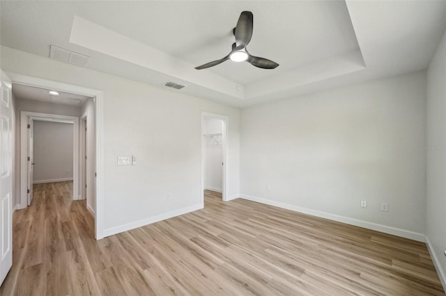 2575 SE 75th Blvd, Bushnell, FL 33513 - spare room with baseboards, a tray ceiling, a ceiling fan, and light wood-type flooring
