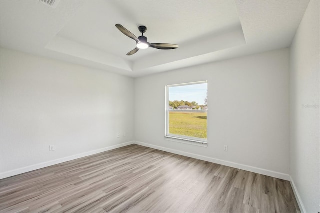 2575 SE 75th Blvd, Bushnell, FL 33513 - unfurnished room featuring visible vents, baseboards, ceiling fan, wood finished floors, and a raised ceiling