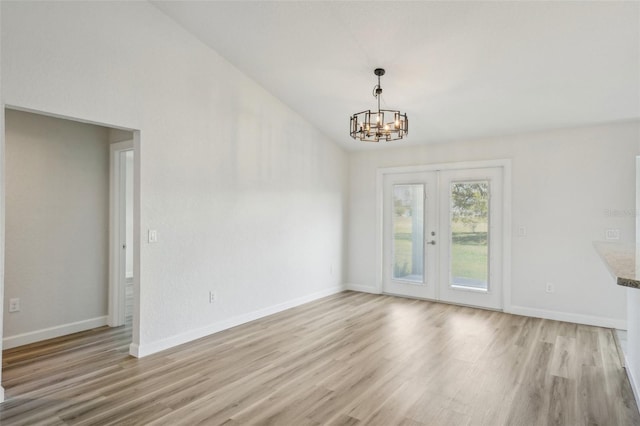 2575 SE 75th Blvd, Bushnell, FL 33513 - empty room with a notable chandelier, french doors, lofted ceiling, light wood-type flooring, and baseboards
