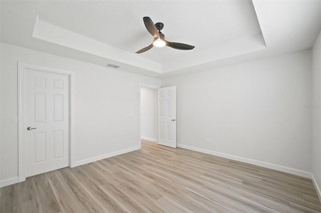 2575 SE 75th Blvd, Bushnell, FL 33513 - spare room with light wood finished floors, a tray ceiling, ceiling fan, and visible vents