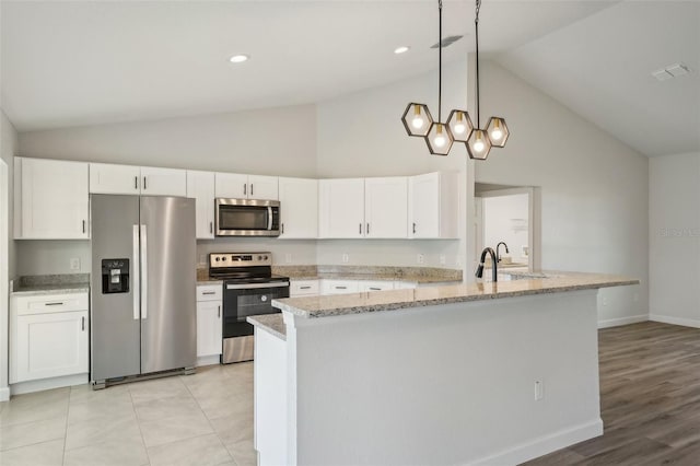 2575 SE 75th Blvd, Bushnell, FL 33513 - kitchen with white cabinets, baseboards, light stone countertops, appliances with stainless steel finishes, and pendant lighting