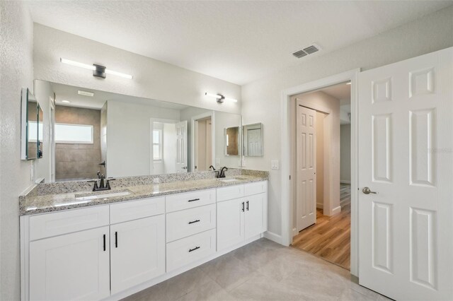 2575 SE 75th Blvd, Bushnell, FL 33513 - full bath with double vanity, visible vents, baseboards, and a sink