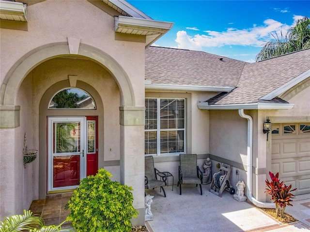 25545 Laurel Valley Rd, Leesburg, FL 34748 - entrance to property with a shingled roof, an attached garage, and stucco siding