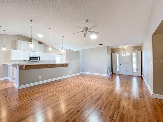 26823 Forest Hills St, Leesburg, FL 34788 - unfurnished living room with light wood-style flooring, baseboards, a ceiling fan, and visible vents
