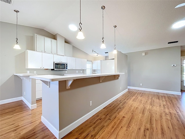 26823 Forest Hills St, Leesburg, FL 34788 - kitchen featuring light wood finished floors, stainless steel microwave, light countertops, and baseboards