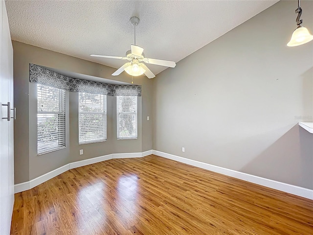 26823 Forest Hills St, Leesburg, FL 34788 - empty room featuring baseboards, a textured ceiling, wood finished floors, lofted ceiling, and ceiling fan
