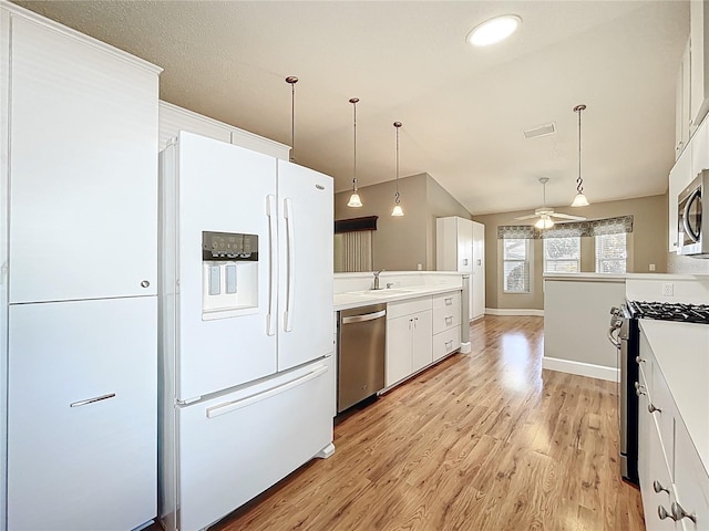 26823 Forest Hills St, Leesburg, FL 34788 - kitchen with white cabinets, light countertops, appliances with stainless steel finishes, ceiling fan, and light wood finished floors