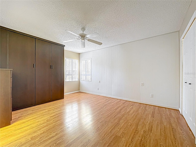 26823 Forest Hills St, Leesburg, FL 34788 - unfurnished bedroom featuring light wood finished floors, a closet, a textured ceiling, and a ceiling fan